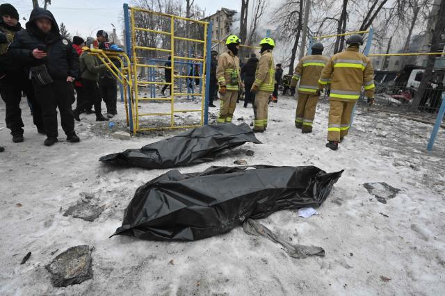 Rescuers stand next to two bodies retrieved from under the rubbles of a five-story residential building which was hit by a ballistic missile in Kharkiv on March 7, 2026 amid the Russian invasion of Ukraine. Russia pummelled Ukraine with drone and missile attacks overnight, killing six people and triggering air alerts across the country, officials said. The bodies of five people were found in the rubble of an apartment block in the eastern Kharkiv region, while one person was killed in the Dnipropetrovsk region. (Photo by SERGEY BOBOK / AFP)
