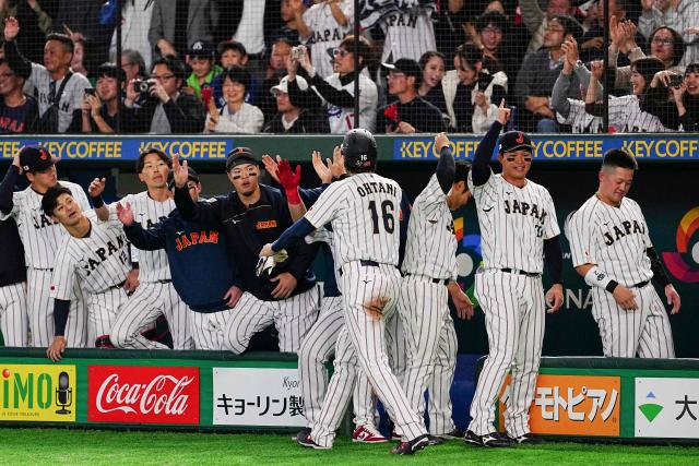 Japan's Shohei Ohtani (C) celebrates with teammates after a score during the World Baseball Classic (WBC) Pool C game between Japan and South Korea at the Tokyo Dome in Tokyo on March 7, 2026. (Photo by Yuichi YAMAZAKI / AFP)