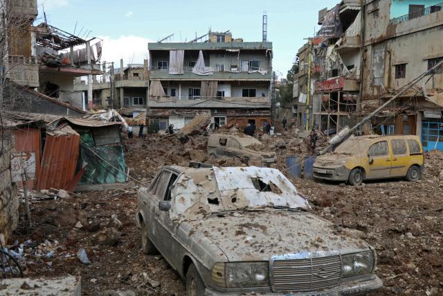 TOPSHOT - This photograph taken during a media tour organised by the Hezbollah shows people inspecting the destruction at Nabi Sheet town after an Israeli military operation in the Bekaa Valley of Lebanon, on March 7, 2026. Hezbollah on March 7 said it confronted Israeli troops that infiltrated an east Lebanon town overnight, with Lebanese authorities reporting at least 16 killed in Israeli strikes on the area. (Photo by Nidal SOLH / AFP)