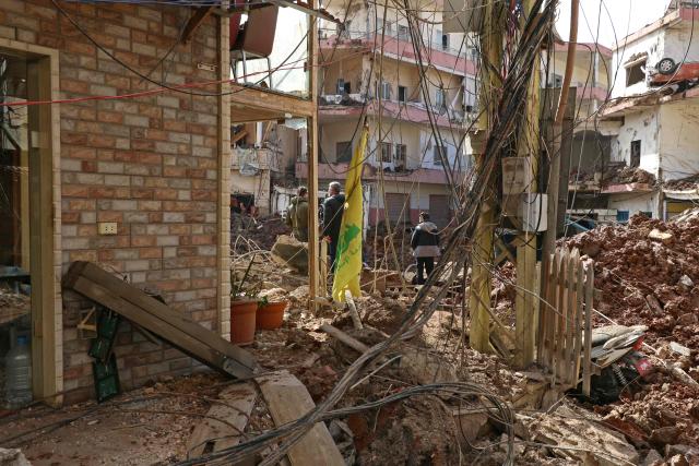 This photograph taken during a media tour organised by the Hezbollah shows people inspecting the destruction at Nabi Sheet town after an Israeli military operation in the Bekaa Valley of Lebanon, on March 7, 2026. Hezbollah on March 7 said it confronted Israeli troops that infiltrated an east Lebanon town overnight, with Lebanese authorities reporting at least 16 killed in Israeli strikes on the area. (Photo by Nidal SOLH / AFP)