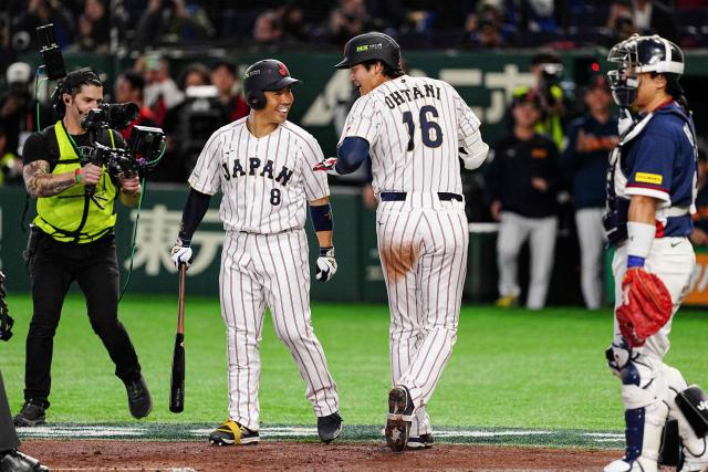 Japan's Shohei Ohtani (2nd R) celebrates with Japan's Kensuke Kondoh (L) after hitting a home run during the World Baseball Classic (WBC) Pool C game between Japan and South Korea at the Tokyo Dome in Tokyo on March 7, 2026. (Photo by Yuichi YAMAZAKI / AFP)