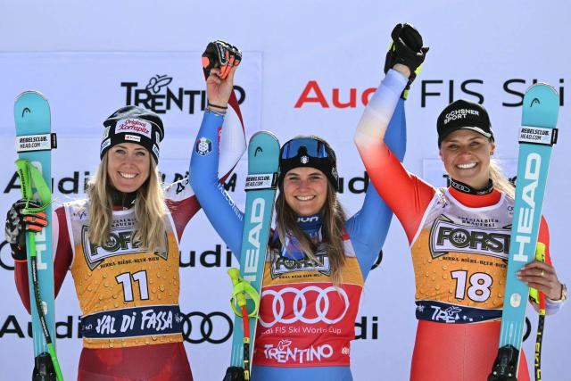(LtoR) Second placed Austria's Cornelia Hutter, winner Italy's Laura Pirovano and third placed Switzerland's Corinne Suter celebrate on the podium after the Women's Downhill race of the FIS Ski World Cup at the La Volata slope in the Passo San Pellegrino ski area, Val di Fassa, Italy on March 7, 2026. (Photo by Andreas SOLARO / AFP)