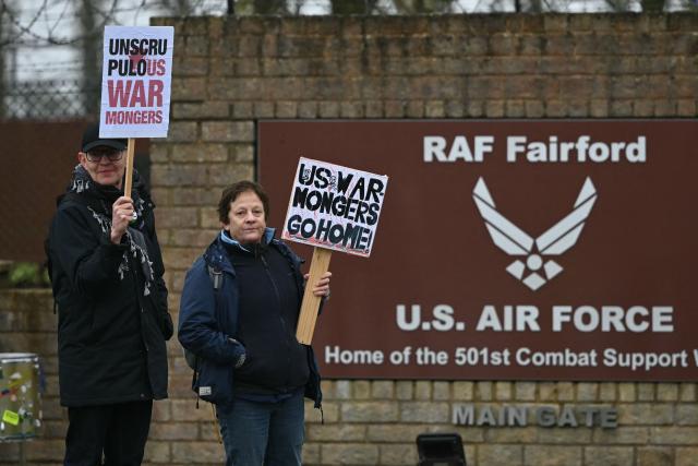 Anti-war protesters gather with placards at an entrance to RAF Fairford in south west England shortly after sunrise on March 7, 2026. Britain's Prime Minister Keir Starmer has given approval for Washington to use the bases of Diego Garcia in the Indian Ocean and RAF Fairford in south-west England to bomb Iranian missile sites, after several Gulf countries were targeted by Iranian retaliations. (Photo by JUSTIN TALLIS / AFP)