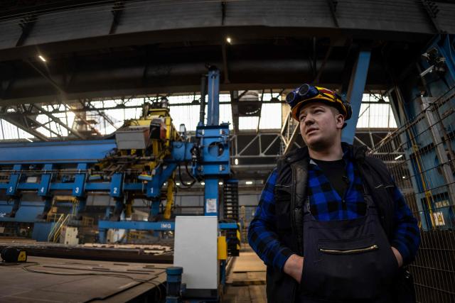 This picture taken on March 6, 2026 shows Robert Sierocki, 20 years old shipyard worker, at the production hall of the Gdansk Shipyard in Gdansk, Poland. The shipyard, known as a birthplace of the Solidarnosc trade union that led to the fall of communism in Poland in 1989, still builds some ships but today, mainly wind turbines are produced at the site. (Photo by Wojtek RADWANSKI / AFP)
