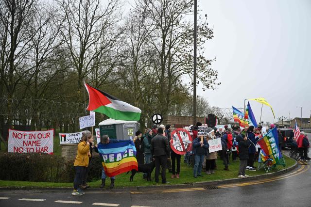 Anti-war protesters gather with banners and placards at an entrance to RAF Fairford in south west England shortly after sunrise on March 7, 2026. Britain's Prime Minister Keir Starmer has given approval for Washington to use the bases of Diego Garcia in the Indian Ocean and RAF Fairford in south-west England to bomb Iranian missile sites, after several Gulf countries were targeted by Iranian retaliations. (Photo by JUSTIN TALLIS / AFP)