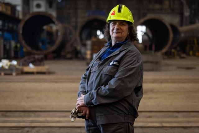 Halina Krauze, 65, a overhead crane operator, poses for a photo in the production hall of the Gdansk Shipyard in Gdansk, Poland, on March 6, 2026. "Around 70% of crane operators on construction sites today are women," Krause explains, a tradition inherited from the communist era. The shipyard, known as the birthplace of the Solidarnosc trade union that led to the fall of communism in Poland in 1989, still builds some ships but today, mainly wind turbines are produced at the site. (Photo by Wojtek RADWANSKI / AFP)