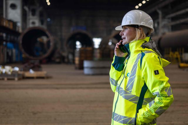 Agnieszka Pyrzanowska, Baltic Industrial Group spokswoman, talks on the phone of the Gdansk Shipyard in Gdansk, Poland, on March 6, 2026. "Around 70% of crane operators on construction sites today are women," according to a worker at the shipyard, a tradition inherited from the communist era. The shipyard, known as the birthplace of the Solidarnosc trade union that led to the fall of communism in Poland in 1989, still builds some ships but today, mainly wind turbines are produced at the site. (Photo by Wojtek RADWANSKI / AFP)