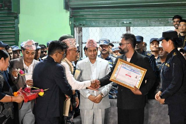 Rastriya Swatantra Party (RSP) election candidate Balendra Shah (centre R) shakes hands with supporters after collecting a certificate for his victory in parliamentary elections at the counting centre in Damak in Nepal's Jhapa district on March 7, 2026. Nepal's rapper-turned-mayor Shah grinned and flashed a V for victory sign on March 7 as Election Commission officials confirmed he had defeated veteran leader KP Sharma Oli in their parliamentary constituency. (Photo by Prakash MATHEMA / AFP)