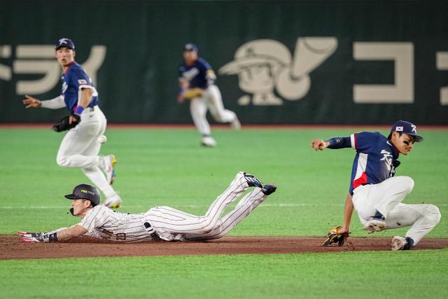 Japan's Ukyo Shuto (L) steals second base during the World Baseball Classic (WBC) Pool C game between Japan and South Korea at the Tokyo Dome in Tokyo on March 7, 2026. (Photo by Yuichi YAMAZAKI / AFP)