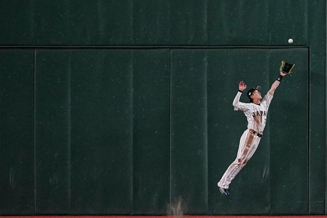 Japan's Ukyo Shuto jumps to catch a fly ball during the World Baseball Classic (WBC) Pool C game between Japan and South Korea at the Tokyo Dome in Tokyo on March 7, 2026. (Photo by Yuichi YAMAZAKI / AFP)