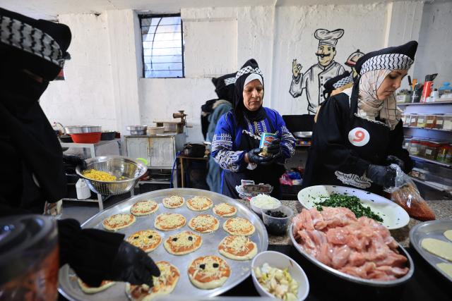 Palestinian displaced women work in a restaurant run by citizen Fatima Al-Ashqar in the Nuseirat refugee camp specialising in making pizza, as they preparer food during the holy month of Ramadan, on the eve of International Women's Day, in the central Gaza Strip on March 7, 2026. Nearly all of Gaza's 2.2 million residents were displaced at least once during the more than two years of war between Israel and Hamas, sparked by the latter's unprecedented October 7 attack on Israel. (Photo by Eyad Baba / AFP)
