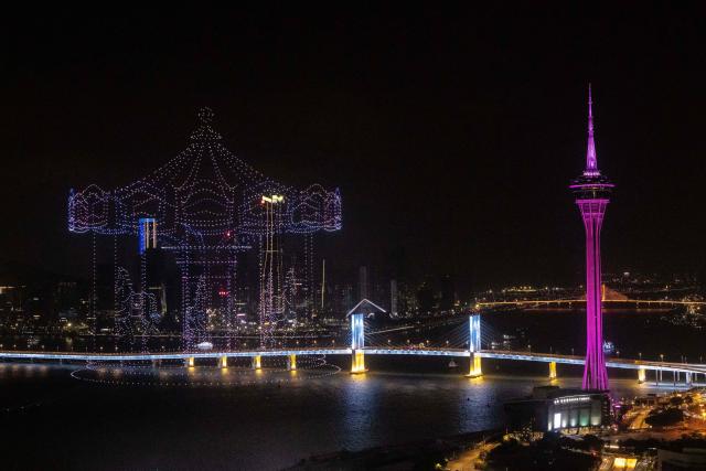 A drone display lights up the sky near the Macau Tower shorefront to mark the official end of the traditional Chinese New Year celebrations in Macau on March 7, 2026. (Photo by Eduardo LEAL / AFP)