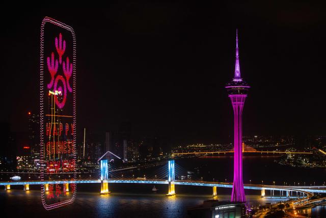A drone display lights up the sky near the Macau Tower shorefront to mark the official end of the traditional Chinese New Year celebrations in Macau on March 7, 2026. (Photo by Eduardo LEAL / AFP)