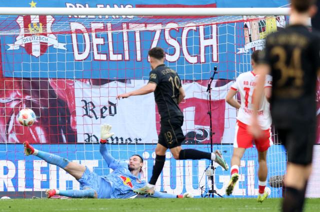 Augsburg's German midfielder #19 Robin Fellhauer (C) scores the 0-1 opening goal against Leipzig's Belgian goalkeeper #26 Maarten Vandevoordt (L) during the Bundesliga football match between RB Leipzig and Augsburg in Leipzig, eastern Germany, on March 7, 2026. (Photo by Ronny HARTMANN / AFP) / DFL REGULATIONS PROHIBIT ANY USE OF PHOTOGRAPHS AS IMAGE SEQUENCES AND/OR QUASI-VIDEO