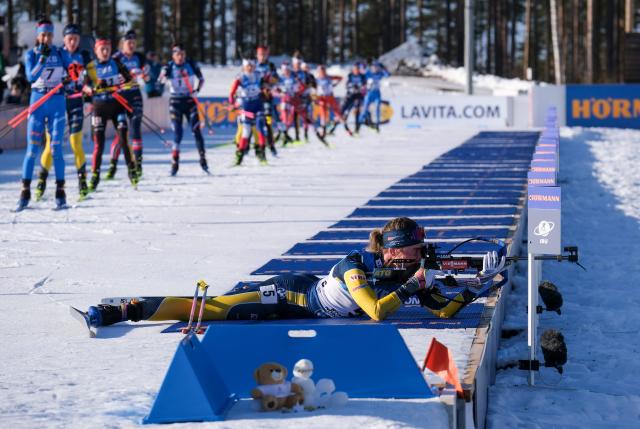 Athletes arrive at the shooting range while Sweden's Elvira Oeberg (R) starts shooting during the IBU World Cup 2026 Kontiolahti Biathlon World Cup Women's Mass Start event on March 7, 2026 in Kontiolahti, Finland. (Photo by Minna Raitavuo / Lehtikuva / AFP) / Finland OUT