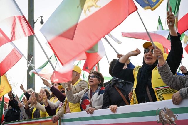 Supporters of the People's Mojahedin Organization of Iran political group wave flags and shout slogans as they take part in a rally "Neither Shah, nor Mullah" to protest against the Islamic Republic of Iran government in Paris on March 7, 2026, amid the ongoing war in the Middle East. (Photo by LOU BENOIST / AFP)