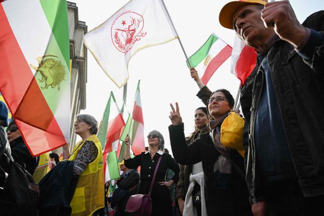 Supporters of the People's Mojahedin Organization of Iran political group wave flags as they take part in a rally "Neither Shah, nor Mullah" to protest against the Islamic Republic of Iran government in Paris on March 7, 2026, amid the ongoing war in the Middle East. (Photo by LOU BENOIST / AFP)