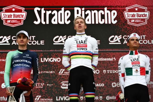(From L) Second placed UCI WorldTeam Decathlon CMA CGM's French Paul Seixas, first placed UAE Team Emirates's Slovenian Tadej Pogacar and third placed Del UAE Team Emirates XRG's MexicanIsaac Del Toro Romero celebrate on the podium after competing in the 20th one-day classic 'Strade Bianche' (White Roads) men's cycling race between Siena and Siena in Tuscany on March 7, 2026. (Photo by Marco BERTORELLO / AFP)