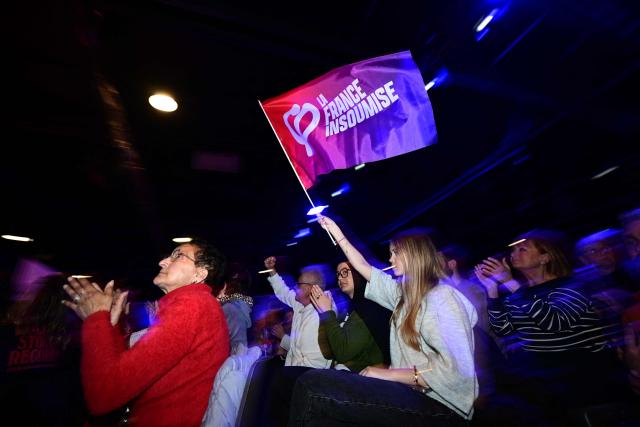 A supporter of French leftist party La France Insoumise (LFI) waves a party flag during a campaign meeting for French municipal elections in Marseille, southern France, on March 7, 2026. French voters head to the polls for municipal elections on March 15 and 22, 2026. (Photo by Miguel MEDINA / AFP)