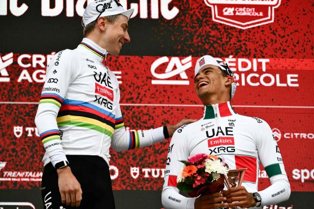 UAE Team Emirates's Slovenian Tadej Pogacar (L) reacts with UAE Team Emirates XRG's Mexican Isaac Del Toro Romero as they celebrate on the podium after competing in the 20th one-day classic 'Strade Bianche' (White Roads) men's cycling race between Siena and Siena in Tuscany on March 7, 2026. (Photo by Marco BERTORELLO / AFP)