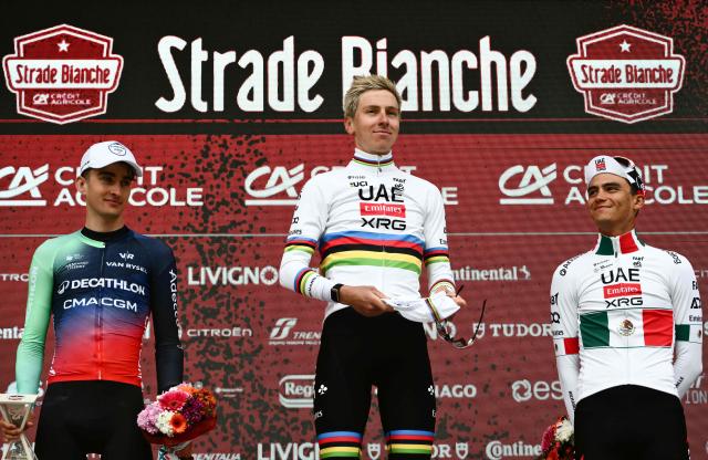 (From L) Second placed UCI WorldTeam Decathlon CMA CGM's French Paul Seixas, first placed UAE Team Emirates's Slovenian Tadej Pogacar and third placed Del UAE Team Emirates XRG's MexicanIsaac Del Toro Romero celebrate on the podium after competing in the 20th one-day classic 'Strade Bianche' (White Roads) men's cycling race between Siena and Siena in Tuscany on March 7, 2026. (Photo by Marco BERTORELLO / AFP)