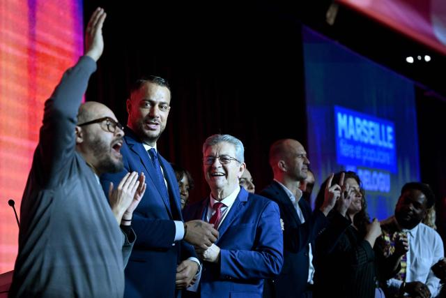 French leftist party La France Insoumise (LFI) leader Jean-Luc Melenchon (3rd R) and mayoral candidate in Marseille Sebastien Delogu (2nd R) react as fellow candidate in Marseille's 7th district Mohamed Bensaada gestures to the crowd at the end of a campaign meeting for French municipal elections in Marseille, southern France, on March 7, 2026. French voters head to the polls for municipal elections on March 15 and 22, 2026. (Photo by Miguel MEDINA / AFP)