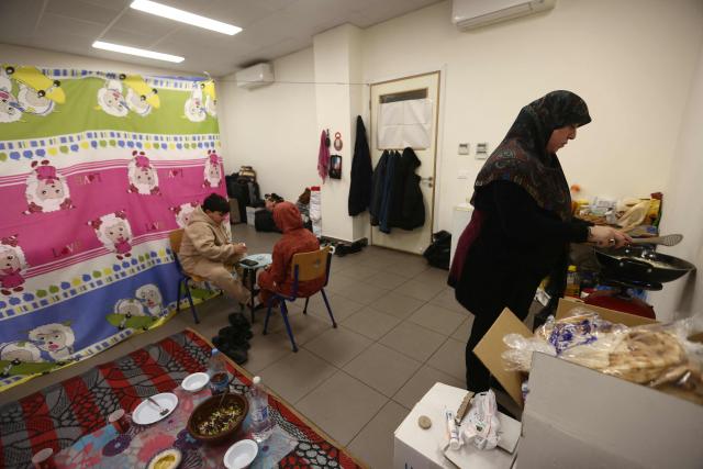 A displaced woman living in a school's classroom after fleeing Israeli airstrikes in Beirut's southern suburbs, prepares their "iftar" fast-breaking meal in Beirut on March 7, 2026. Lebanon's social affairs minister said on March 7, that 454,000 people had been registered as displaced since the outbreak of the new war between Israel and Hezbollah. In a press briefing, Haneen Sayed said that the total number of people who registered their names on a website affiliated with the ministry reached 454,000, including 112,525 people registered in government shelters. (Photo by Ibrahim AMRO / AFP)