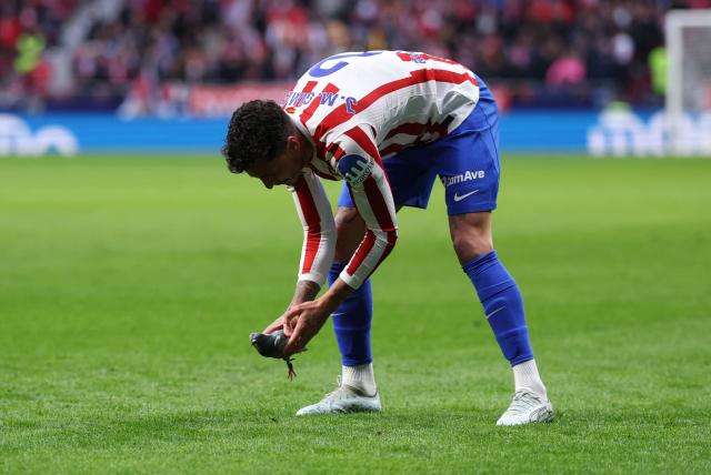 Atletico Madrid's Uruguayan defender #02 Jose Gimenez catches a pigeon to take it off the pitch during the Spanish league football match between Club Atletico de Madrid and Real Sociedad at Metropolitano Stadium in Madrid on March 7, 2026. (Photo by Thomas COEX / AFP)