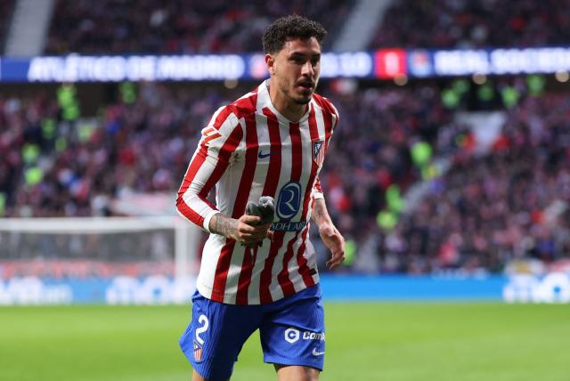 Atletico Madrid's Uruguayan defender #02 Jose Gimenez catches a pigeon to take it off the pitch during the Spanish league football match between Club Atletico de Madrid and Real Sociedad at Metropolitano Stadium in Madrid on March 7, 2026. (Photo by Thomas COEX / AFP)