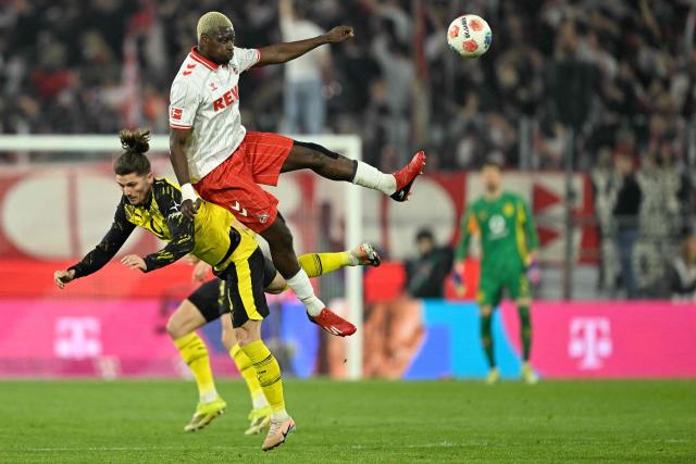 Dortmund's Austrian midfielder #20 Marcel Sabitzer (L) and FC Cologne's German forward #09 Ragnar Ache vie for the ball during the German first division Bundesliga football match 1 FC Cologne v BVB Borussia Dortmund in Cologne, western Germany, on March 7, 2026. (Photo by INA FASSBENDER / AFP) / DFL REGULATIONS PROHIBIT ANY USE OF PHOTOGRAPHS AS IMAGE SEQUENCES AND/OR QUASI-VIDEO