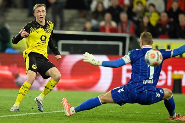 Dortmund's German forward #14 Maximilian Beier (L) scores the 0-2 goal past FC Cologne's German goalkeeper #01 Marvin Schwaebe during the German first division Bundesliga football match 1 FC Cologne v BVB Borussia Dortmund in Cologne, western Germany, on March 7, 2026. (Photo by INA FASSBENDER / AFP) / DFL REGULATIONS PROHIBIT ANY USE OF PHOTOGRAPHS AS IMAGE SEQUENCES AND/OR QUASI-VIDEO
