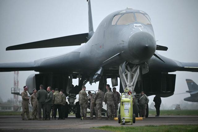 US Military personnel and ground crew talk after disembarking from a US Air Force B-1 Lancer bomber at RAF Fairford in south west England shortly after sunrise on March 7, 2026. Britain's Prime Minister Keir Starmer has given approval for Washington to use the bases of Diego Garcia in the Indian Ocean and RAF Fairford in south-west England to bomb Iranian missile sites, after several Gulf countries were targeted by Iranian retaliations. (Photo by JUSTIN TALLIS / AFP)