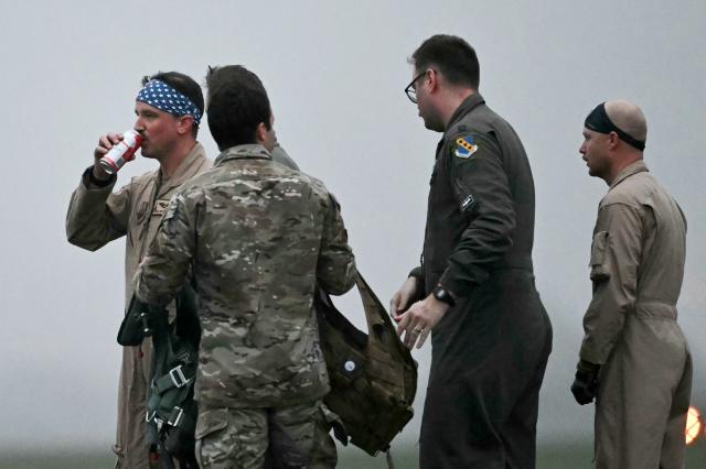 A US Military crewman swigs a drink after disembarking from a US Air Force B-1 Lancer bomber at RAF Fairford in south west England shortly after sunrise on March 7, 2026. Britain's Prime Minister Keir Starmer has given approval for Washington to use the bases of Diego Garcia in the Indian Ocean and RAF Fairford in south-west England to bomb Iranian missile sites, after several Gulf countries were targeted by Iranian retaliations. (Photo by JUSTIN TALLIS / AFP)