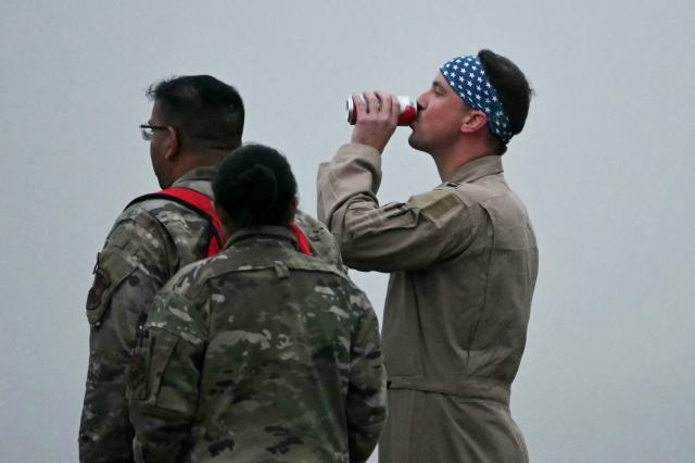 A US Military crewman swigs a drink after disembarking from a US Air Force B-1 Lancer bomber at RAF Fairford in south west England shortly after sunrise on March 7, 2026. Britain's Prime Minister Keir Starmer has given approval for Washington to use the bases of Diego Garcia in the Indian Ocean and RAF Fairford in south-west England to bomb Iranian missile sites, after several Gulf countries were targeted by Iranian retaliations. (Photo by JUSTIN TALLIS / AFP)