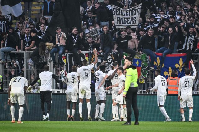 Angers' players celebrate victory with supporters at the end of the French L1 football match between FC Nantes and SCO Angers at the Stade de la Beaujoire–Louis Fonteneau in Nantes, western France on March 7, 2026. (Photo by Sebastien Salom-Gomis / AFP)