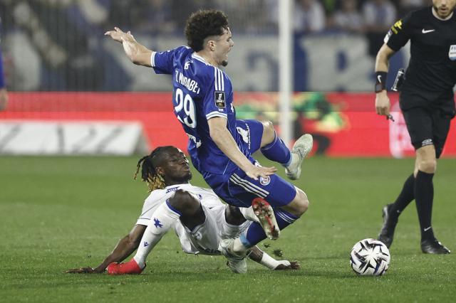Strasbourg's French midfielder #29 Samir El Mourabet (R) is tackled by Auxerre's Ghanaian defender #14 Gideon Mensah (L) during the French L1 football match between AJ Auxerre and RC Strasbourg Alsace at the Stade de l'Abbe-Deschamps in Auxerre, central France, on March 7, 2026. (Photo by Kenzo TRIBOUILLARD / AFP)