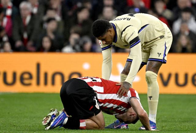 Barcelona's English forward #14 Marcus Rashford helps Athletic Bilbao's Spanish defender #02 Andoni Gorosabel (down) during the Spanish league football match between Athletic Club Bilbao and FC Barcelona at San Mames Stadium in Bilbao on March 7, 2026. (Photo by ANDER GILLENEA / AFP)