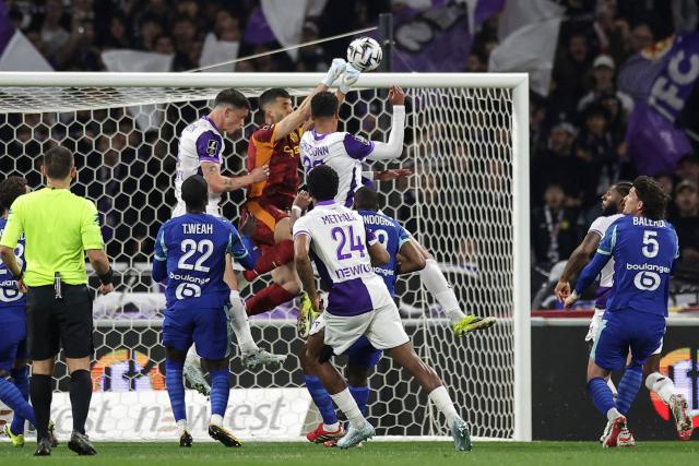 Marseille's Argentinian goalkeeper #01 Geronimo Rulli (C) stops the ball during the French L1 football match between Toulouse FC and Olympique de Marseille (OM) at the TFC Stadium in Toulouse, southwestern France, on March 7, 2026. (Photo by Valentine CHAPUIS / AFP)