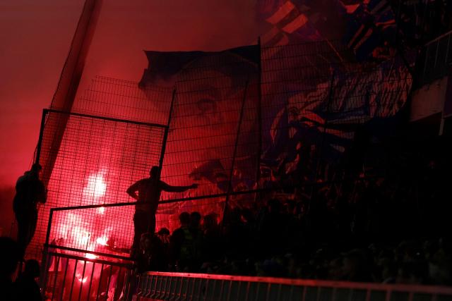 Strasbourg's supporters light red flares during the French L1 football match between AJ Auxerre and RC Strasbourg Alsace at the Stade de l'Abbe-Deschamps in Auxerre, central France, on March 7, 2026. (Photo by Kenzo TRIBOUILLARD / AFP)