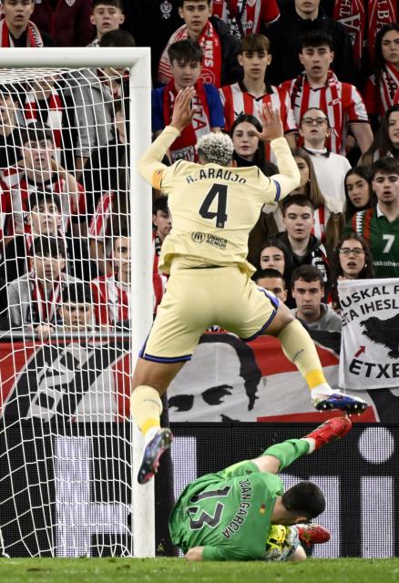 Barcelona's Spanish goalkeeper #13 Joan Garcia catches the ball next to Barcelona's Uruguayan defender #04 Ronald Federico Araujo da Silva (up) during the Spanish league football match between Athletic Club Bilbao and FC Barcelona at San Mames Stadium in Bilbao on March 7, 2026. (Photo by ANDER GILLENEA / AFP)