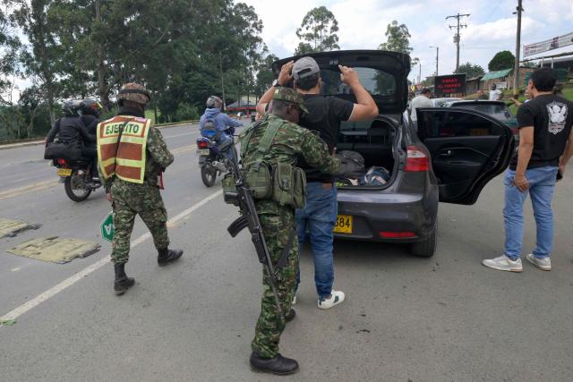 A Colombian soldier searches a man at a roadside checkpoint on the Pan-American Highway in Tunia, Cauca department, Colombia, on the eve of the legislative elections, on March 7, 2026. Colombia will hold legislative elections on March 8 and presidential elections on May 31. (Photo by Joaquin SARMIENTO / AFP)