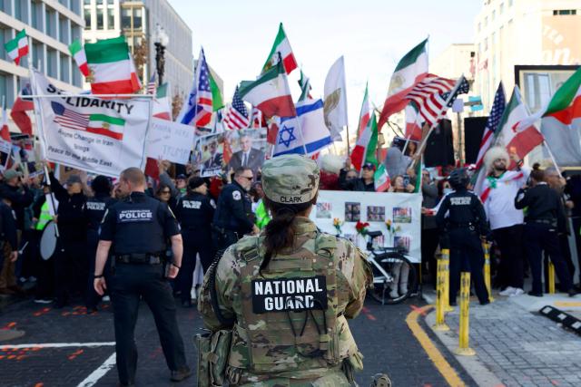 Police and members of the National Guard stand in front of demonstrators from the Iranian diaspora waving pre-Islamic revolution Iranian, Israeli and US flags as they protest against the Iranian government in front of the White House in Washington, DC, on March 7, 2026. Protesters gathered in the US capital to denounce the Iranian regime and express solidarity with anti-government movements in Iran. (Photo by Amid FARAHI / AFP)