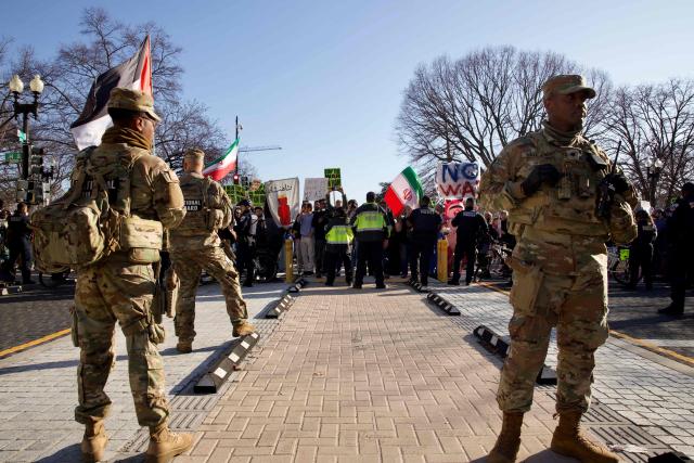 Police and members of the National Guard stand in front of demonstrators gathering in front of the White House to protest against the war with Iran in Washington, DC, on March 7, 2026. Participants called for diplomacy and warned against military escalation with Iran during the rally in the US capital. (Photo by Amid FARAHI / AFP)