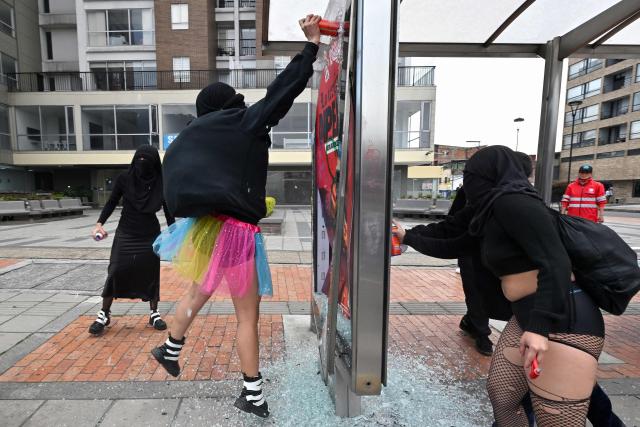 Demonstrators damage a bus station during a rally on the eve of International Women's Day in Bogota on March 7, 2026. (Photo by Diana SANCHEZ / AFP)