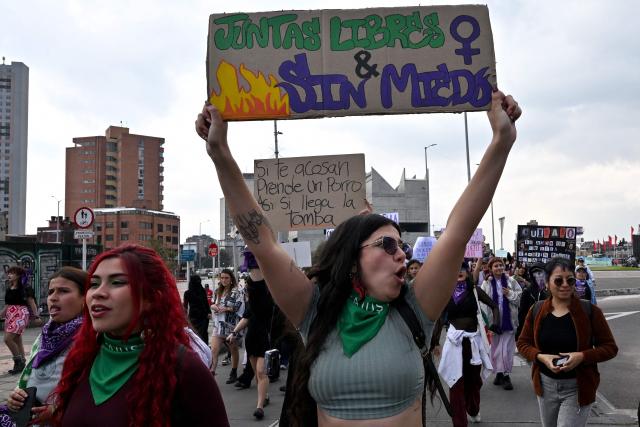 A demonstrator shows a sign that reads "Free & Fearless Together" during a rally on the eve of International Women's Day in Bogota on March 7, 2026. (Photo by Diana SANCHEZ / AFP)
