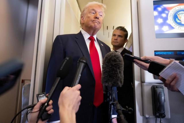 US President Donald Trump speaks with the media as Defense Secretary Pete Hegseth looks on aboard Air Force One during a flight from Dover, Delaware, to Miami, Florida, on March 7, 2026. (Photo by SAUL LOEB / AFP)
