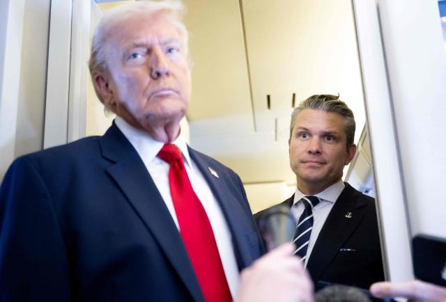 US President Donald Trump speaks with the media as Defense Secretary Pete Hegseth looks on aboard Air Force One during a flight from Dover, Delaware, to Miami, Florida, on March 7, 2026. (Photo by SAUL LOEB / AFP)