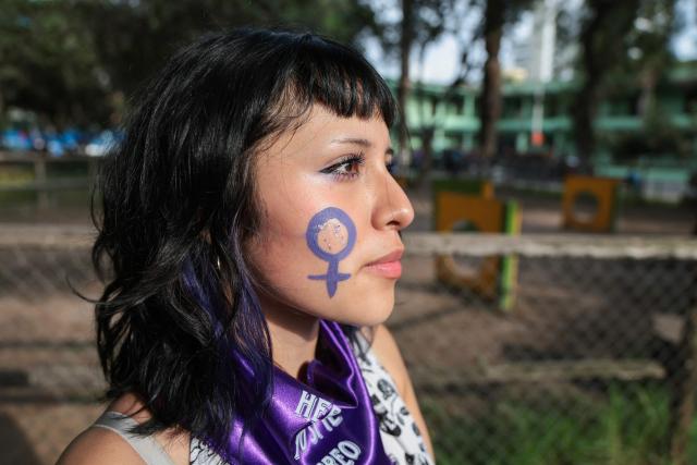 A demonstrator shows the Venus symbol painted on her cheek during a march on the eve of International Women's Day in Lima on March 7, 2026. (Photo by Connie FRANCE / AFP)