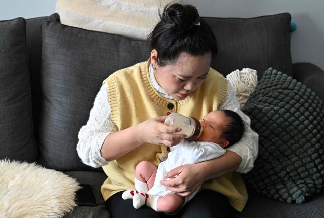 Zhang Xiaofei gives milk to her newborn baby Zhu Wanning in Langfang, northern China's Hebei province on March 6, 2026. The world's second-most populous country is threatened with a demographic crisis after its birth rate halved over the past decade -- all while people rapidly age out of the workforce. (Photo by Adek BERRY / AFP) / TO GO WITH AFP STORY: China-economy-demographics-infants, by Mary YANG