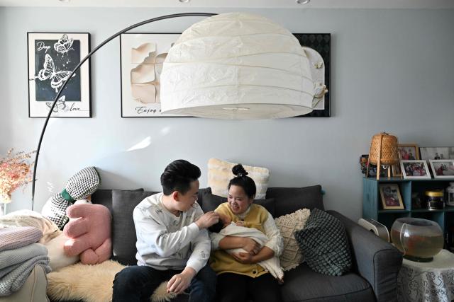 Zhang Xiaofei (R) holds her newborn baby Zhu Wanning next to her husband Zhu Yunfei (L) in Langfang, northern China's Hebei province on March 6, 2026. The world's second-most populous country is threatened with a demographic crisis after its birth rate halved over the past decade -- all while people rapidly age out of the workforce. (Photo by Adek BERRY / AFP) / TO GO WITH AFP STORY: China-economy-demographics-infants, by Mary YANG
